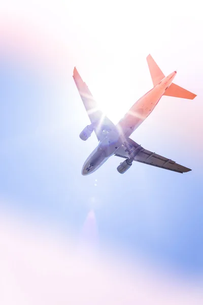 Avión comercial volando por encima de las nubes con cielo azul en el fondo — Foto de Stock