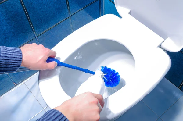 Мужчина чистки туалета с помощью кисти и жидкости очиститель — стоковое фото