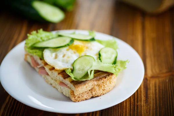 Sandwich with sausage, cheese, lettuce and eggs — Stock Photo, Image