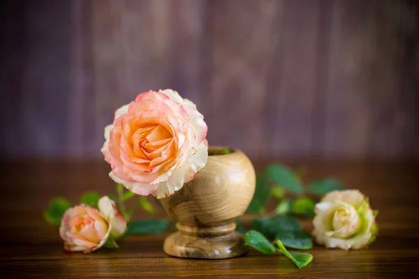 Pequeno buquê de belas rosas cor-de-rosa em uma mesa de madeira — Fotografia de Stock