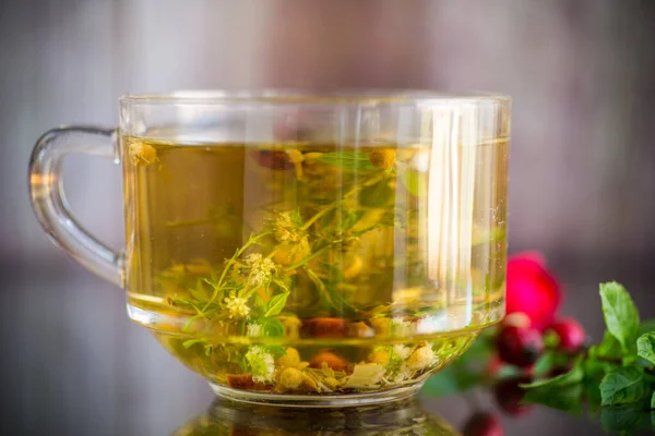 Naturalna gorąca herbata z różnych letnich ziół w szklanej filiżance — Zdjęcie stockowe