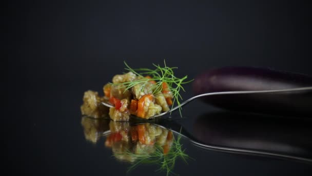Cooked summer eggplant caviar with vegetables on black background — Stock Video