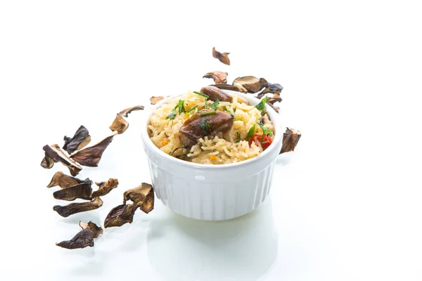 用干枯的森林蘑菇煮熟的米 放在一个用白色背景隔开的碗里 — 图库照片