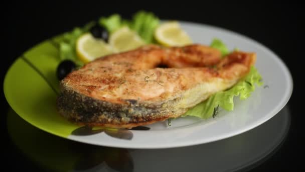 Pezzo di pesce salmone fritto in un piatto con limone — Video Stock