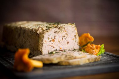 İçinde mantar ve sebzeler olan kıymalı sosisten yapılmış ahşap bir masa.