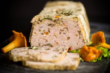 İçinde mantar ve sebze bulunan ev yapımı kıymalı et sosisi, siyah arka planda izole edilmiş.