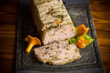 İçinde mantar ve sebzeler olan kıymalı sosisten yapılmış ahşap bir masa.