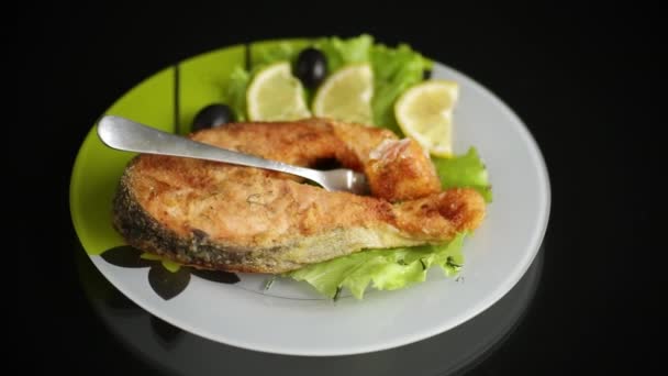 Шматок смаженої риби лосося в тарілці з лимоном — стокове відео