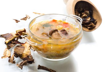 Porcini mantarlı vejetaryen sebze çorbası beyaz arka planda izole edilmiş cam bir kasede.