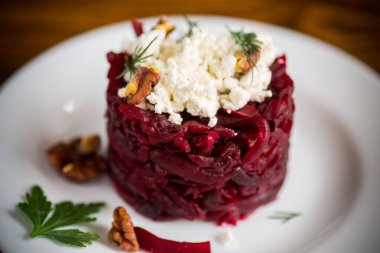 Ahşap bir masada cevizli ve süzme peynirli haşlanmış pancar salatası.