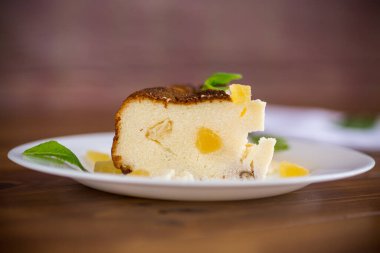 ahşap bir masanın üzerinde fındıklı ve şekerli meyveli tatlı süzme peynir güveci.