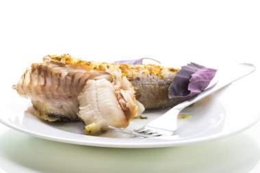 Baharatlı fırında pişirilmiş balık, beyaz arka planda izole edilmiş baharatlar.