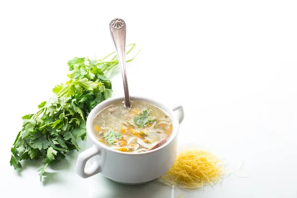 cooked hot soup with noodles and vegetables in a plate isolated on white background