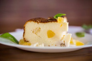 ahşap bir masanın üzerinde fındıklı ve şekerli meyveli tatlı süzme peynir güveci.