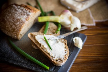 Tahta masaya sarımsaklı peynirli ev yapımı karabuğday ekmeği.