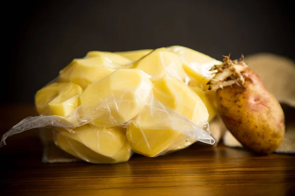 Geschilde Aardappelen Gesloten Een Vacuümzak Oude Gekiemde Aardappelen Een Houten — Stockfoto