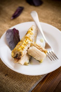 Fırında pişirilmiş balık, baharatlar ve tabakta baharatlar.