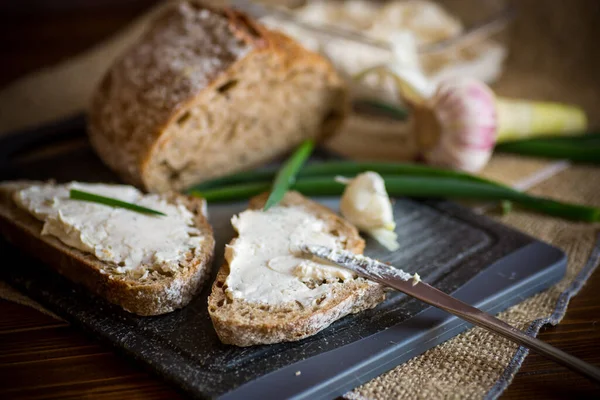 木のテーブルの上にガーリックチーズがのった自家製そばパン — ストック写真