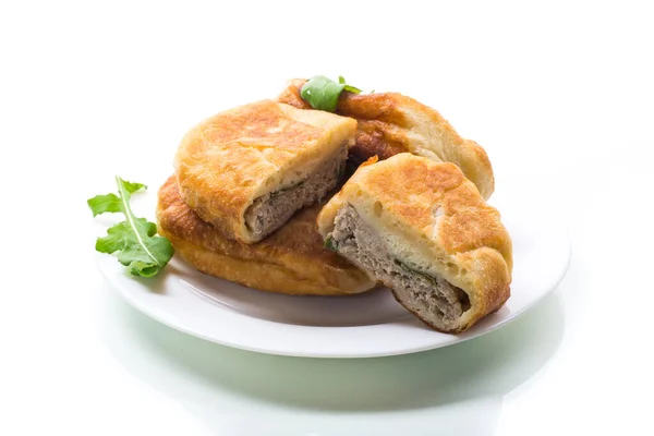 fried pies with meat in a plate on a white background