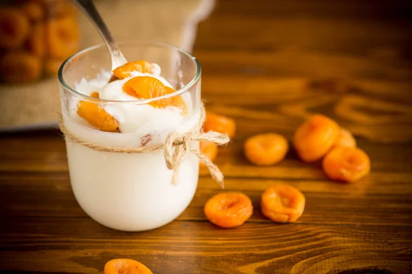 Hemgjord Söt Yoghurt Ett Glas Med Torkade Aprikoser Ett Träbord — Stockfoto