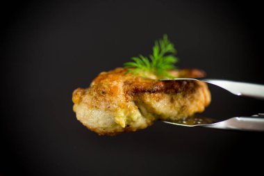 Siyah arka planda baharatlı kızarmış tavuk filetosu.