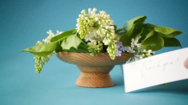 Bir demet beyaz leylak ve tebrik kartı.