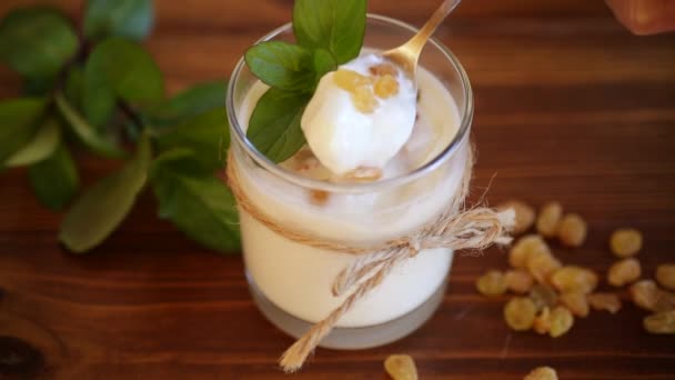 Sweet homemade yogurt with raisins in a glass — Stock Video