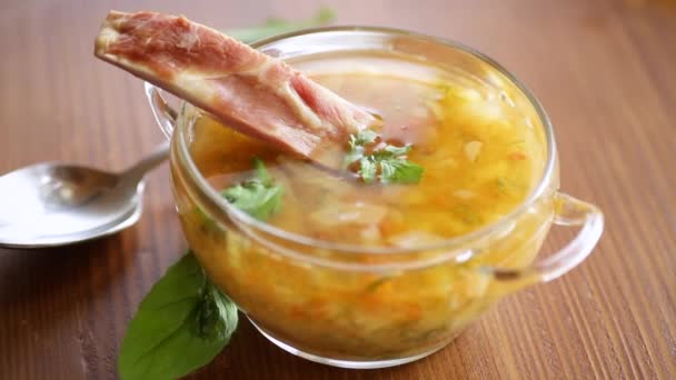 Zuppa di piselli cotti con costole affumicate in un piatto — Video Stock