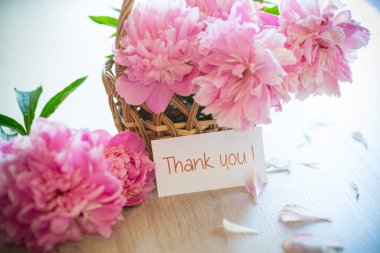 Tahta bir arka planda çiçek açan pembe şakayık dalları.