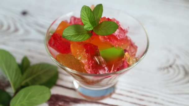 Gekleurd zoet fruit gelei in een glas — Stockvideo