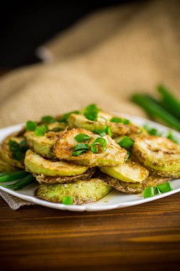 Tabakta taze otlarla daireler çizerek kızarmış kabak.