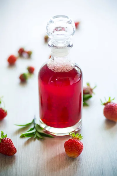 将甜草莓糖浆放入玻璃瓶中 — 图库照片