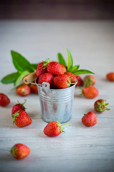 Röda mogna naturliga jordgubbar på ett träbord — Stockfoto