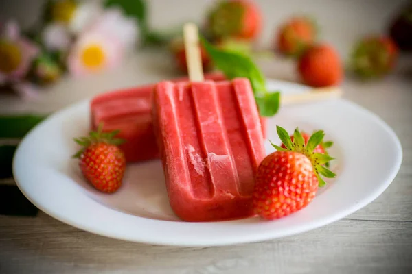 Zelfgemaakte aardbeienijs op een stokje gemaakt van verse aardbeien in een bord — Stockfoto