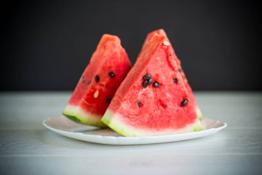 Tahta bir masada taze olgun kırmızı karpuz parçaları.