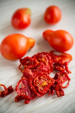 Bir avuç kuru domates ve taze domatesler.