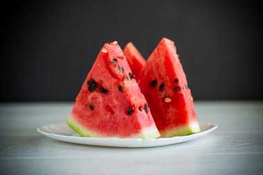 Tahta bir masada taze olgun kırmızı karpuz parçaları.