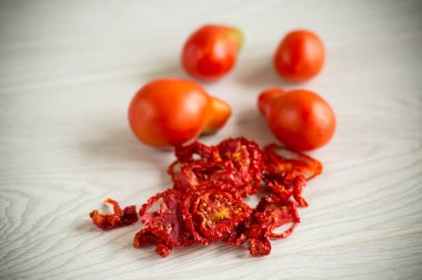 Bir avuç kuru domates ve taze domatesler.