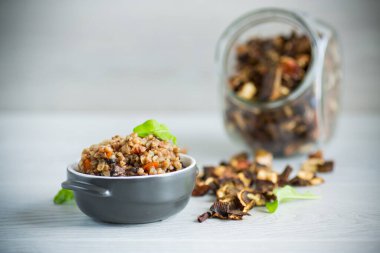 Sebzeli haşlanmış karabuğday ve seramik kalıpta kurutulmuş orman mantarı.