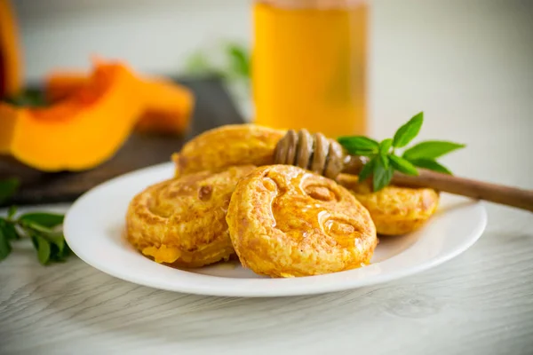 Zoete weelderige pompoen pannenkoeken met honing in een bord — Stockfoto