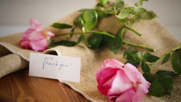 Ροζ όμορφα καλοκαιρινά τριαντάφυλλα σε ξύλινο τραπέζι — Αρχείο Βίντεο