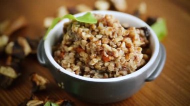 Sebzeli haşlanmış karabuğday ve seramik kalıpta kurutulmuş orman mantarı.