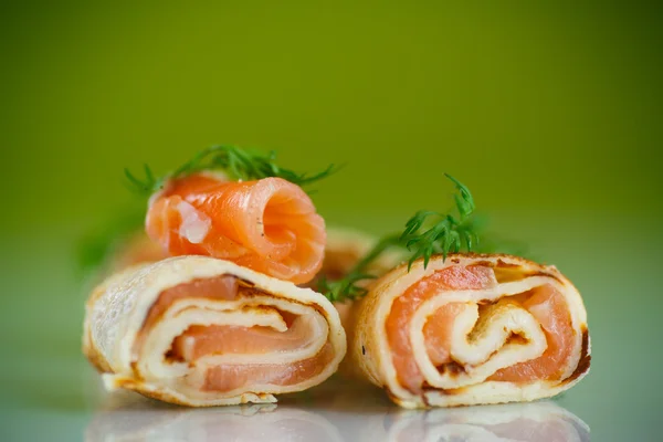 Rolls of thin pancakes with salted red fish — Stock Photo, Image