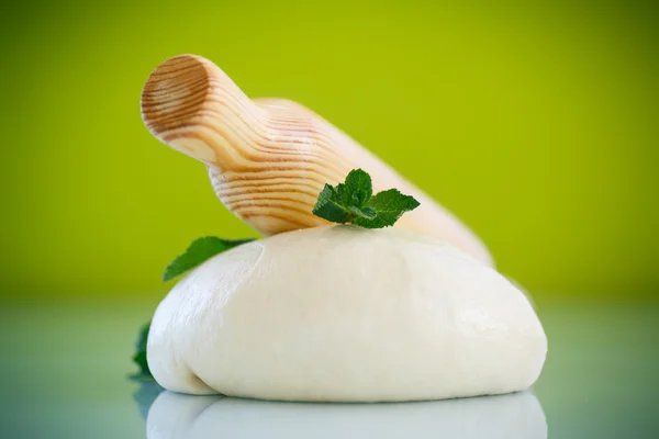 Yeast dough with a wooden rolling pin — Stock Photo, Image