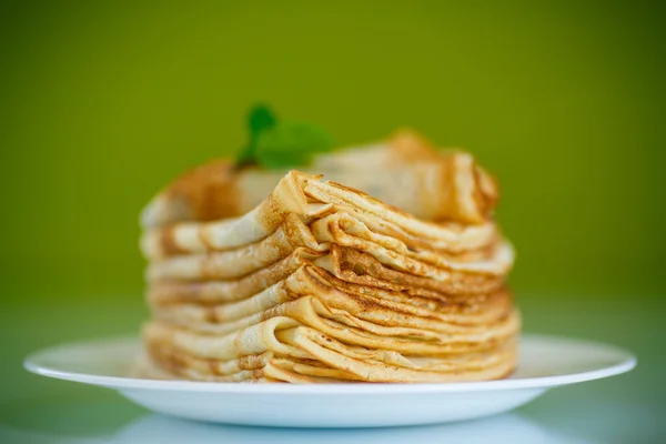 Viele dünne Pfannkuchen auf einem Teller — Stockfoto