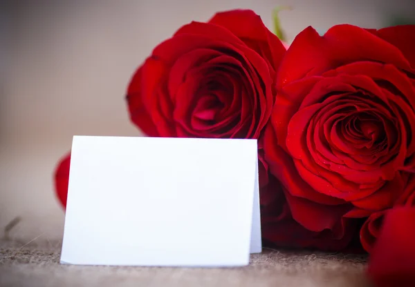 Beau bouquet de roses rouges sur une vieille table de toile de jute — Photo