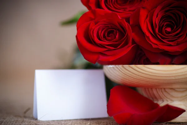 Beau bouquet de roses rouges sur une vieille table de toile de jute — Photo