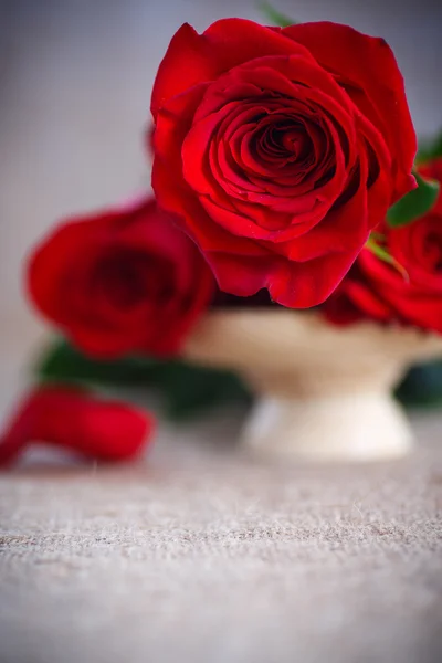 Beautiful bouquet of red roses on an old table of burlap — Stock Photo, Image