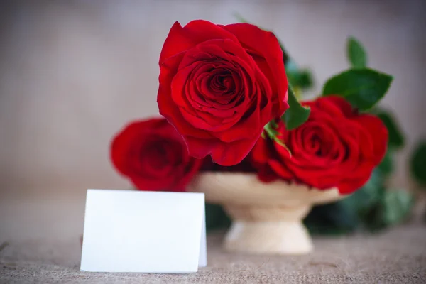 Hermoso ramo de rosas rojas en una vieja mesa de arpillera —  Fotos de Stock