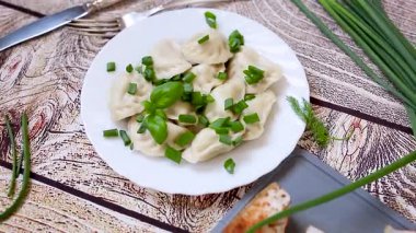 Hafif ahşap bir masada soğanlı sıcak hamur köfteleri.